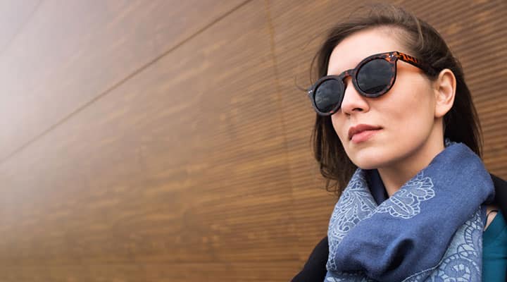 Confident woman wearing sunglasses and blue scarf maximizes her brain with power of periwinkle