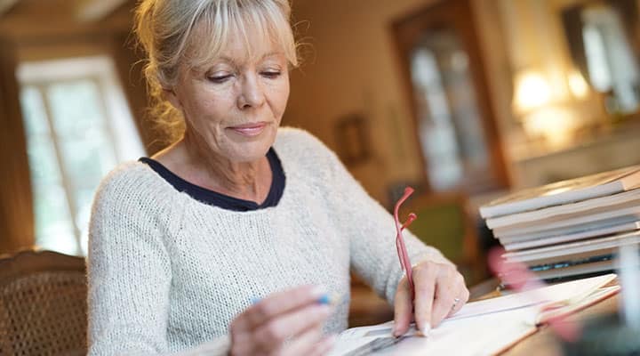 Intelligent older woman who protects herself against dementia with huperzine A, reading a book