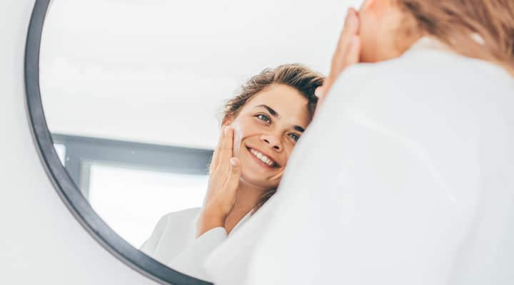 Woman in mirror using collagen to keep skin and joints youthful