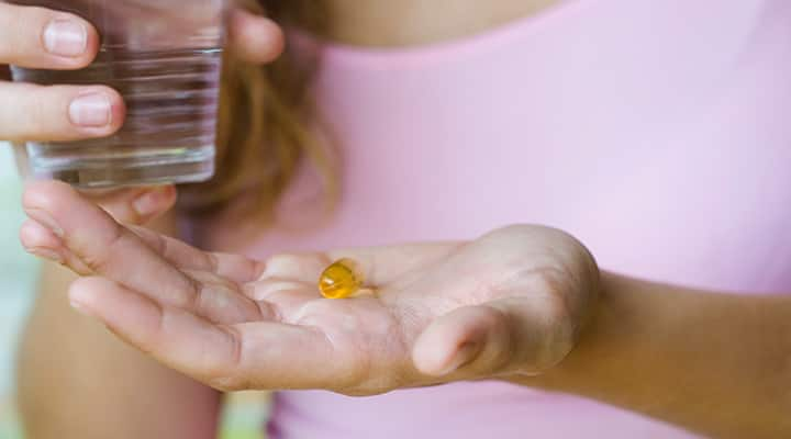 Woman taking CoQ10 supplement for heart health