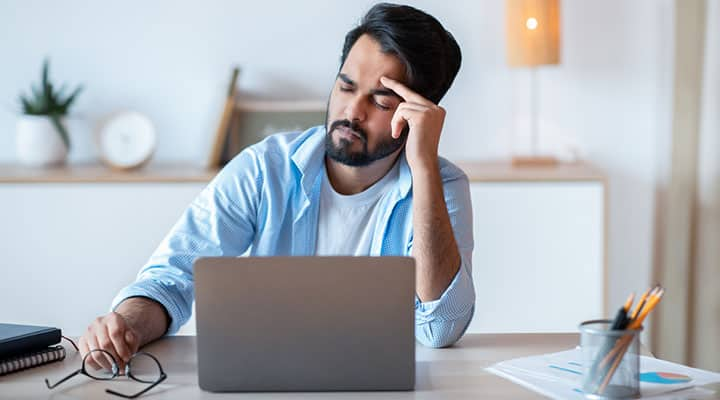 Man sitting at his computer looking frazzled