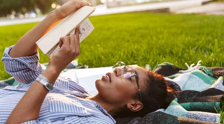 Woman enjoying benefits of ashwagandha on brain health reading in the park