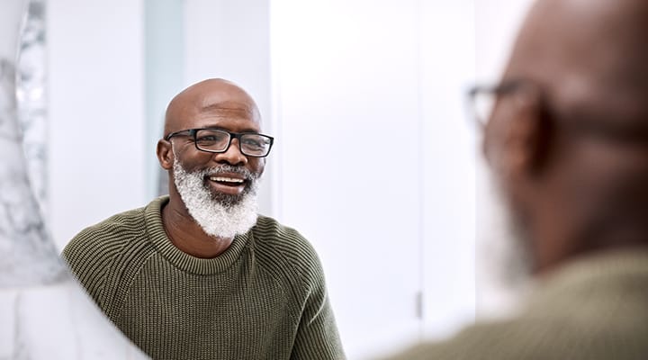 Smiling man looking in the mirror