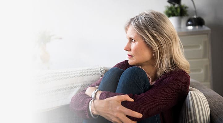 Woman curled up on the couch gathering her thoughts