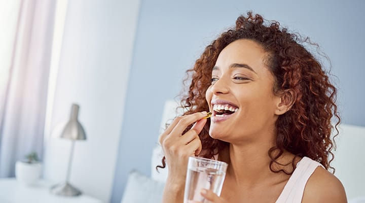 Woman taking a vegan supplement