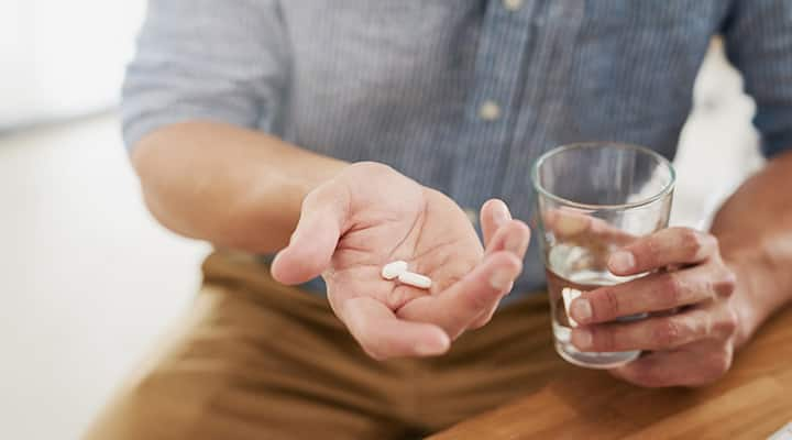 Man with vegan supplement and water