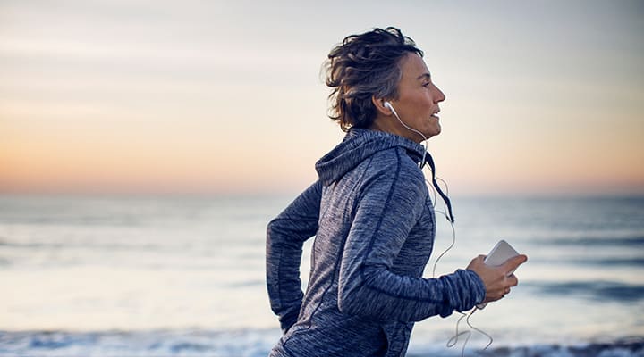 Woman jogging with earphones along the beach