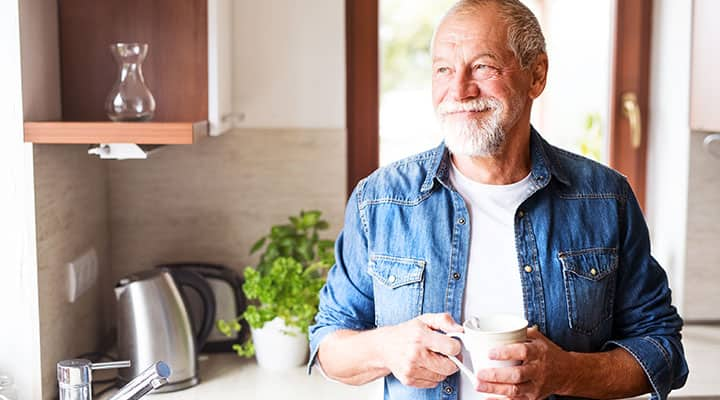 Older man standing in kitchen with more energy