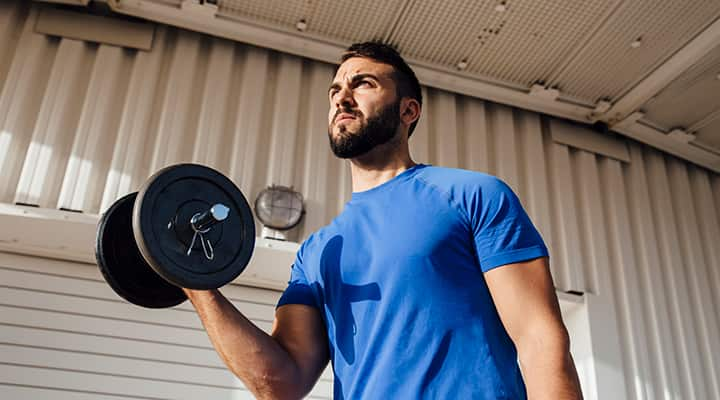 Man who takes sports supplements lifting weights